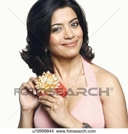 Portrait of a young woman holding a gift View Large Photo Image Picture - Portrait of a young woman holding a gift. Fotosearch