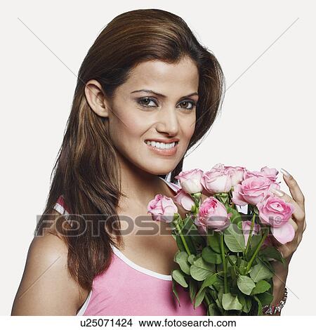 Picture - Portrait of a young woman holding a bunch of flowers. Fotosearch