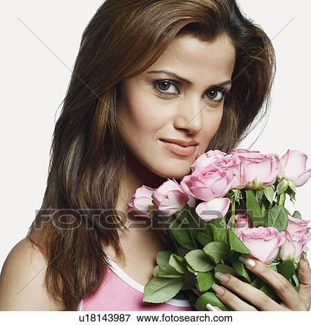 Stock Photo - Portrait of a young woman holding a bunch of flowers. Fotosearch