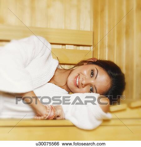 Stock Photograph - Portrait of a young woman lying in a sauna. Fotosearch