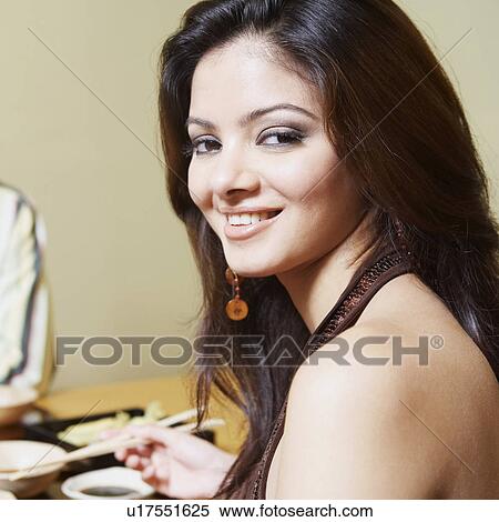 Portrait of a young woman sitting at the dining table and smiling View Large Photo Image Stock Photography - Portrait of a young woman sitting at the dining table and smiling. Fotosearch