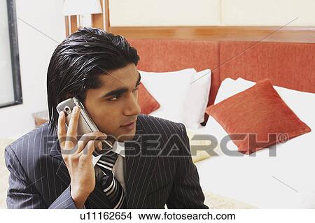 Close-up of a businessman talking on a mobile phone View Large Photo Image Picture - Close-up of a businessman talking on a mobile phone. Fotosearch