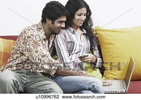 Stock Image - Close-up of a young couple working on a laptop. Fotosearch