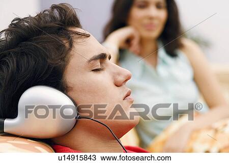 Close-up of a young man listening to music View Large Photo Image Stock Image - Close-up of a young man listening to music. Fotosearch