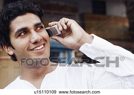 Stock Photo - Close-up of a young man talking on a mobile phone. Fotosearch
