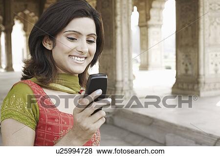 Close-up of a young woman holding a mobile phone View Large Photo Image Stock Photo - Close-up of a young woman holding a mobile phone. Fotosearch