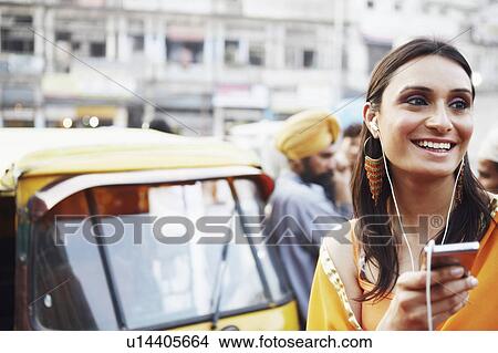 Picture - Close-up of a young woman listening to an MP3 player. Fotosearch