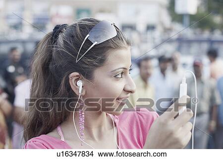 Picture - Close-up of a young woman listening to an MP3 player. Fotosearch