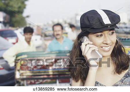 Close-up of a young woman talking on a mobile phone View Large Photo Image Stock Photography - Close-up of a young woman talking on a mobile phone. Fotosearch