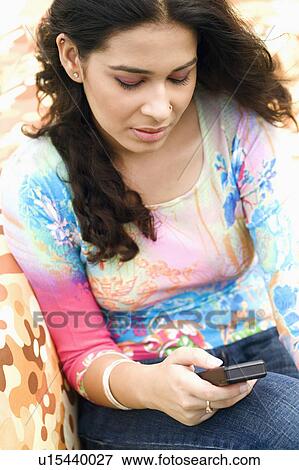 Close-up of a young woman using a mobile phone View Large Photo Image Stock Photo - Close-up of a young woman using a mobile phone. Fotosearch