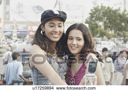 Close-up of two young women taking a photograph of themselves View Large Photo Image Picture - Close-up of two young women taking a photograph of themselves. Fotosearch