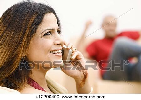 Stock Image - Mid adult woman talking on a mobile phone. Fotosearch