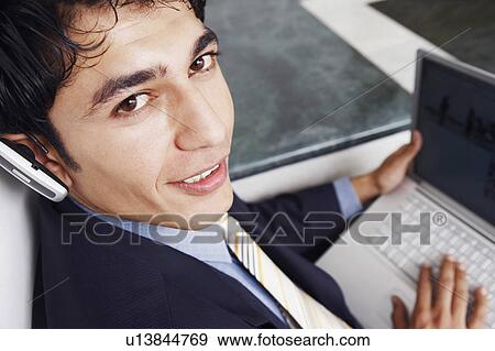 Stock Photo - Portrait of a businessman using a laptop. Fotosearch