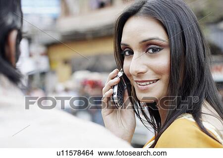 Portrait of a young woman talking on a mobile phone View Large Photo Image Picture - Portrait of a young woman talking on a mobile phone. Fotosearch