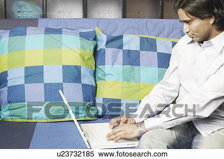 Stock Photography - Young man using a laptop. Fotosearch