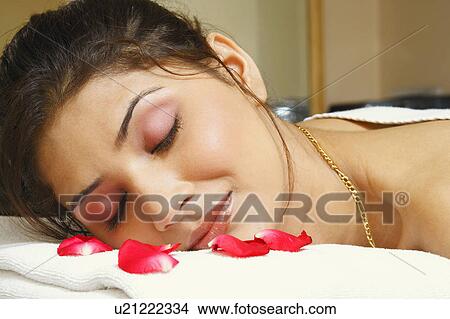 Picture - Close-up of a young woman lying on a massage table. Fotosearch