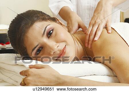 Portrait of a young woman getting a shoulder massage from a massage therapist View Large Photo Image Stock Image - Portrait of a young woman getting a shoulder massage from a massage therapist. Fotosearch