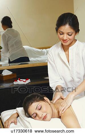 Young woman getting a shoulder massage from a massage therapist View Large Photo Image Stock Photo - Young woman getting a shoulder massage from a massage therapist. Fotosearch