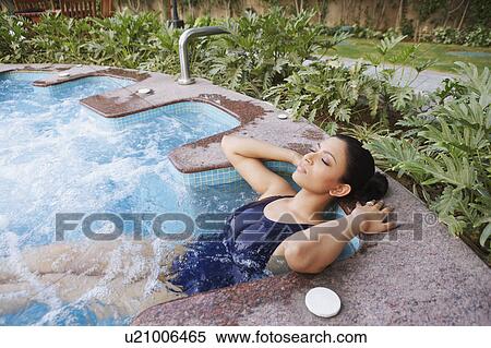 Young woman lying in a swimming pool with her eyes closed View Large Photo Image Stock Photography - Young woman lying in a swimming pool with her eyes closed. Fotosearch