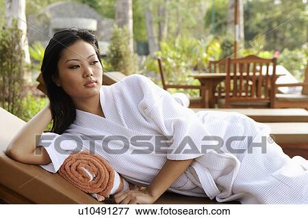 Young woman lying on her side with her head in her hand View Large Photo Image Stock Photo - Young woman lying on her side with her head in her hand. Fotosearch