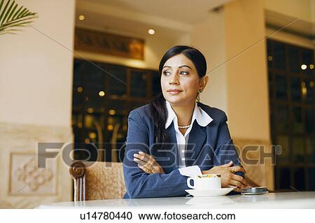 Businesswoman sitting in a cafeteria View Large Photo Image Stock Image - Businesswoman sitting in a cafeteria. Fotosearch