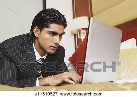 Stock Photo - Close-up of a businessman using a laptop. Fotosearch