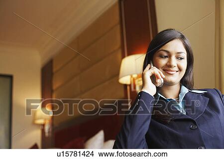 Picture - Low angle view of a businesswoman talking on a mobile phone. Fotosearch