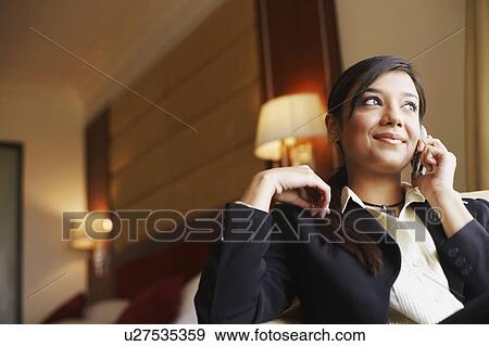 Low angle view of a businesswoman talking on a mobile phone View Large Photo Image Stock Photo - Low angle view of a businesswoman talking on a mobile phone. Fotosearch