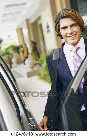 Portrait of a businessman entering a car and carrying a bag View Large Photo Image Stock Image - Portrait of a businessman entering a car and carrying a bag. Fotosearch