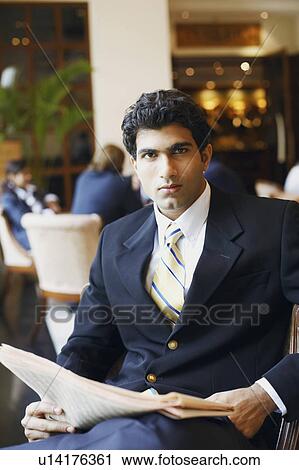 Stock Image - Portrait of a businessman holding a newspaper. Fotosearch