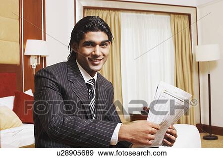 Stock Photo - Portrait of a businessman holding a newspaper. Fotosearch