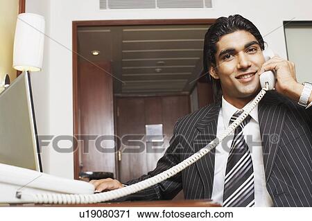 Stock Image - Portrait of a businessman talking on the telephone. Fotosearch