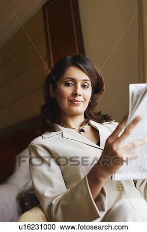 Portrait of a businesswoman holding a newspaper View Large Photo Image Stock Image - Portrait of a businesswoman holding a newspaper. Fotosearch