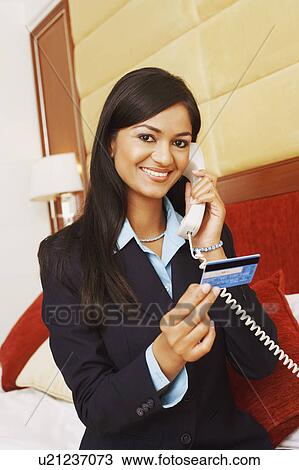 Portrait of a businesswoman talking on the telephone and holding a credit card View Large Photo Image Stock Image - Portrait of a businesswoman talking on the telephone and holding a credit card. Fotosearch