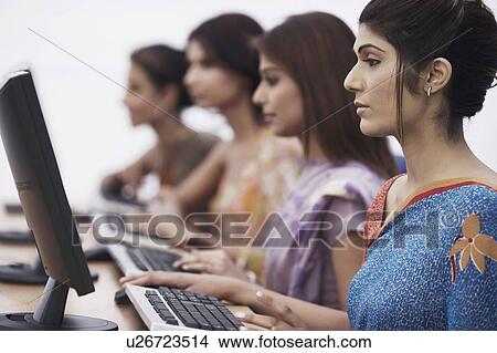 Picture - Close-up of four businesswomen sitting in front of computers. Fotosearch