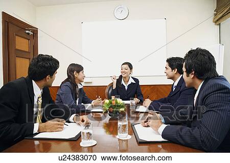 Stock Image - Five business executives at a meeting in a conference room. Fotosearch