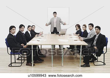 Stock Image - Portrait of a businessman showing thumbs up in a conference room. Fotosearch