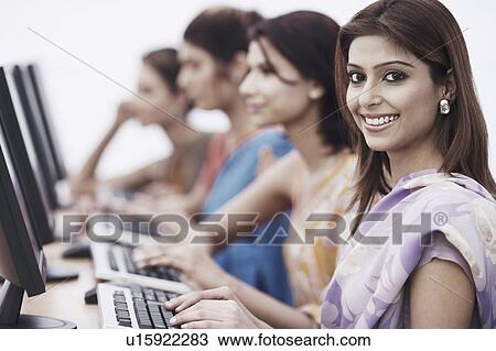 Stock Image - Portrait of a businesswoman sitting in front of a computer. Fotosearch
