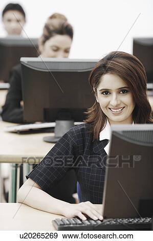 Portrait of a businesswoman sitting in front of a computer View Large Photo Image Stock Photo - Portrait of a businesswoman sitting in front of a computer. Fotosearch