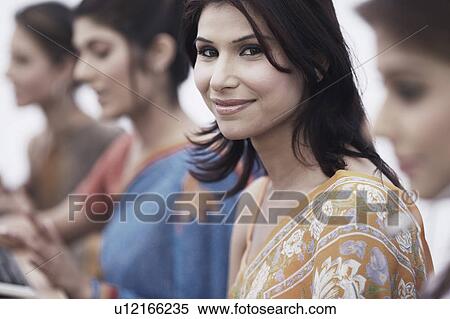 Stock Photography - Portrait of a businesswoman sitting with her colleagues. Fotosearch