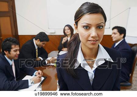 Stock Photograph - Portrait of a businesswoman with four business executives sitting behind her. Fotosearch