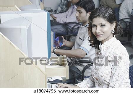 Stock Photography - Portrait of a female office worker working in an office. Fotosearch