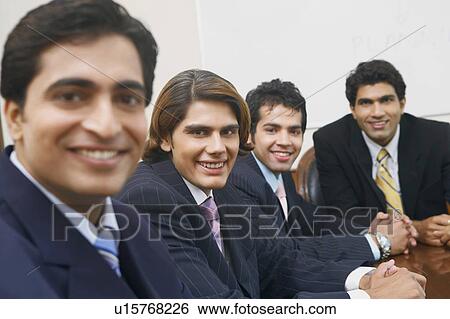 Portrait of four businessmen sitting in a conference room View Large Photo Image Stock Photograph - Portrait of four businessmen sitting in a conference room. Fotosearch