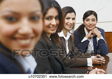 Portrait of four businesswomen sitting in a conference room View Large Photo Image Stock Image - Portrait of four businesswomen sitting in a conference room. Fotosearch