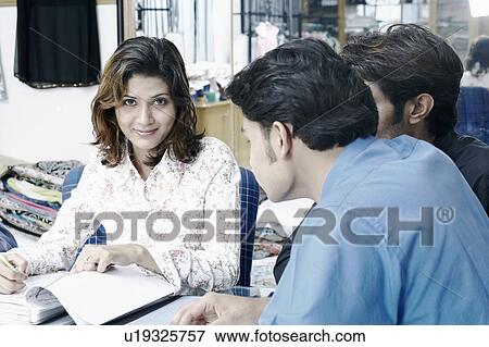 Two businessmen and a businesswoman in a conference room View Large Photo Image Stock Photo - Two businessmen and a businesswoman in a conference room. Fotosearch