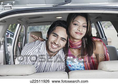 Stock Photograph - Close-up of a young couple sitting in a car. Fotosearch