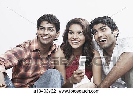 Stock Image - Close-up of a young woman and two young men smiling. Fotosearch