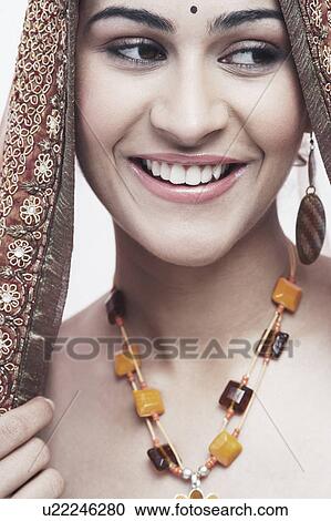 Stock Image - Close-up of a young woman in traditional clothing smiling. Fotosearch