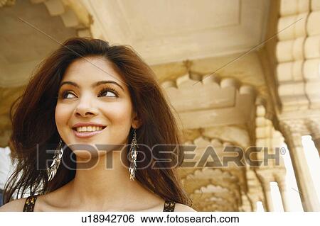 Close-up of a young woman smiling, Agra Fort, Agra, Uttar Pradesh, India View Large Photo Image Stock Photograph - Close-up of a young woman smiling, Agra Fort, Agra, Uttar Pradesh, India. Fotosearch