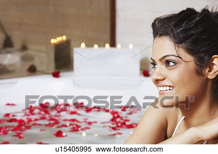 Stock Photography - Close-up of a young woman smiling in a bathtub. Fotosearch